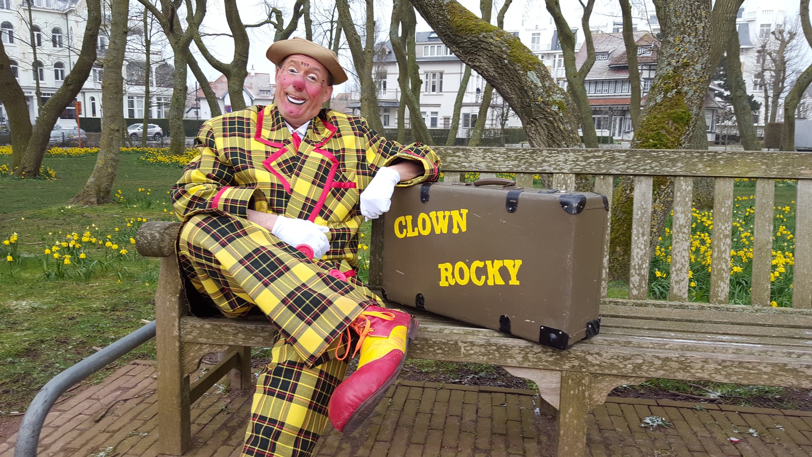 Clown Rocky tijdens een kleurrijke en interactieve kindershow, omringd door lachende kinderen en ouders