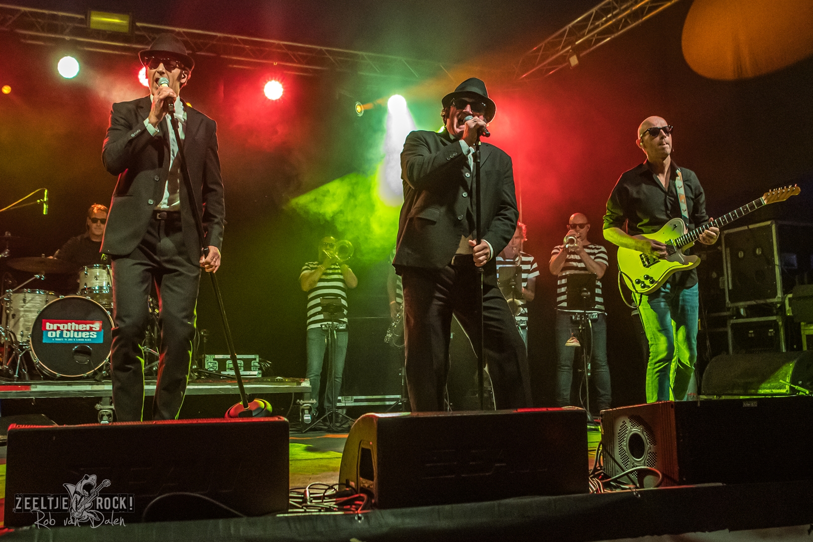 Brothers of Blues tribute band live in actie met zwarte pakken, zonnebrillen en swingende muziek op het podium