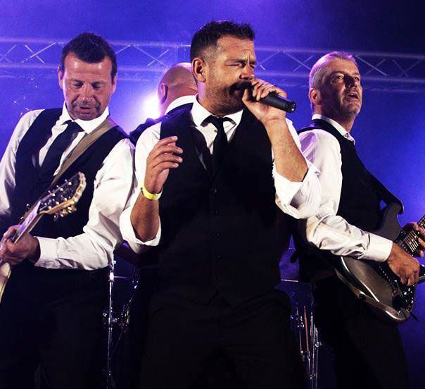 Live optreden van De Kreunaers coverband tijdens een feestelijk evenement vol meezingende fans