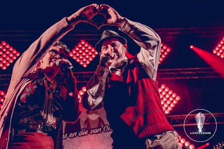 Fons en Die van Ons coverband live op het podium in kostuums, dansend en zingend met het publiek
