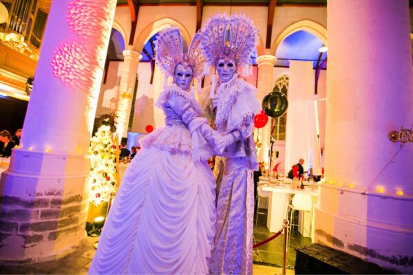 Festa Venezia, twee Venetiaanse steltenlopers in maagdelijk wit tussen de gasten, te boeken via Dream Animations.